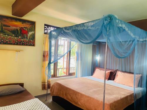 ein Schlafzimmer mit einem Himmelbett in der Unterkunft Sitha's Heaven in Ella