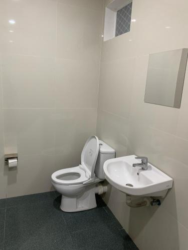 a bathroom with a toilet and a sink at Passifika Hotel Maluk in Maluk
