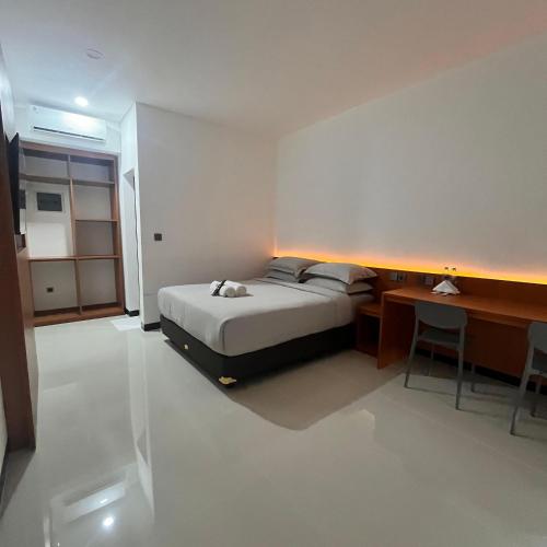 a bedroom with a bed and a desk and a desk at Passifika Hotel Maluk in Maluk