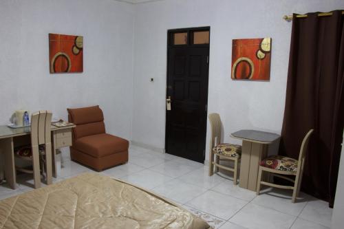 a room with a bed and a table and a door at Hill View Hotel McCarthy Hills in Bortianor