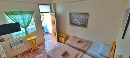 uma sala de estar com um sofá e uma televisão em Scenic View Tourist Inn em San Juan