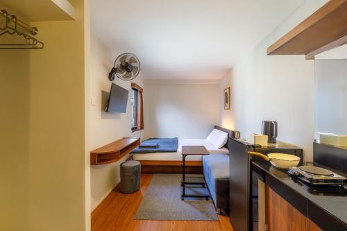 a small room with a bed and a kitchen at Andewi Cabin in Canggu