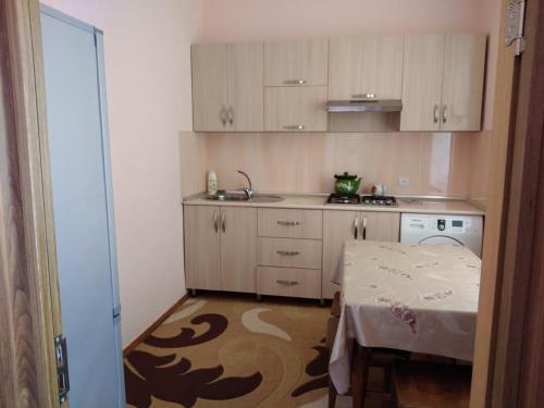 una cucina con mobili bianchi e un tavolo di Qusar house a Qusar