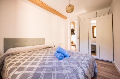 a bedroom with a bed with a blue pillow on it at Rural apartment La Cantonada in Guardiola de Berguedà