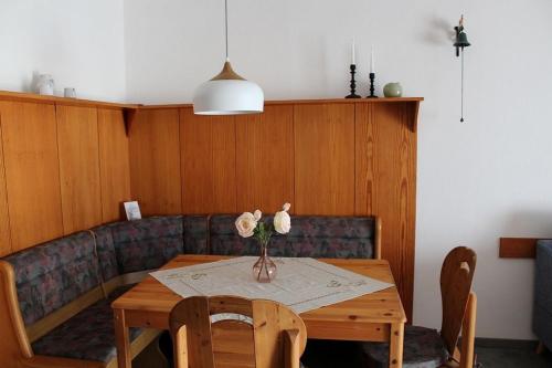 Ferienhaus Nr 124, Kategorie Economy, Feriendorf Hochbergle, Allgäu في Karlsebene: طاولة غرفة الطعام مع إناء من الزهور عليها