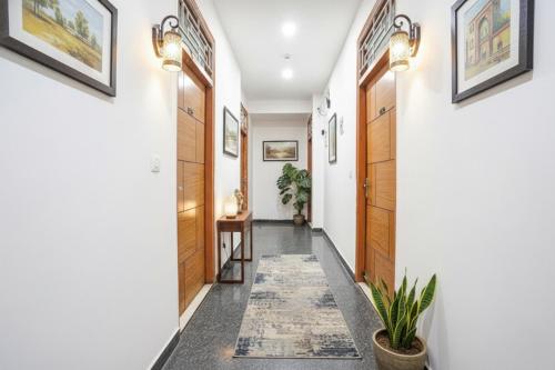 um corredor com portas de madeira e um tapete em Via Prime Residency em Nova Deli