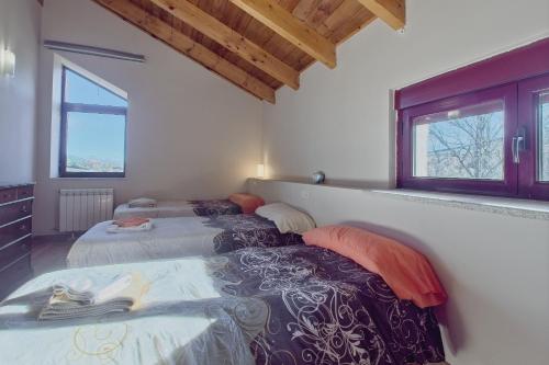 zwei Betten in einem Zimmer mit zwei Fenstern in der Unterkunft Casa Rural Ucedo in Ucedo