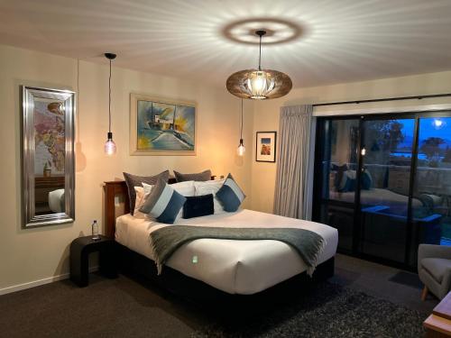 Un dormitorio con una cama grande y una ventana. en Incredible mountain & sea views, en Mapua