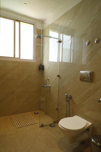 ein Badezimmer mit Toilette und Glasdusche in der Unterkunft Shimla Golf Resorts in Shimla