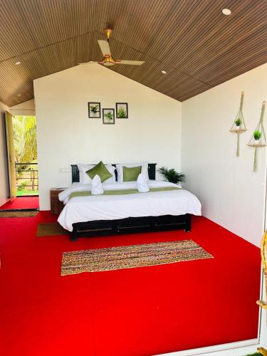 a bedroom with a bed with a red carpet at Casa Beach hut Resort in Palolem