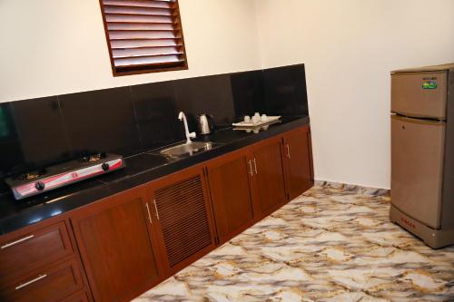 a kitchen with a sink and a refrigerator at Chatu villa in Ahangama