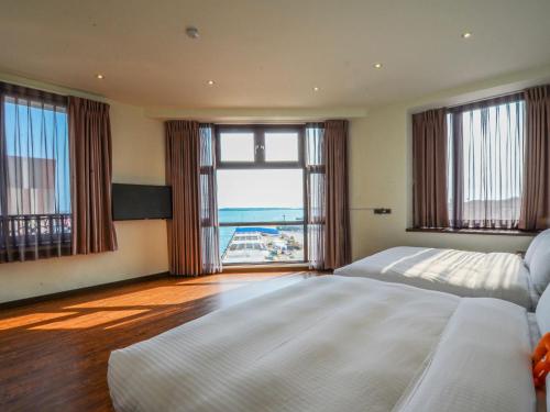 a bedroom with a large bed and a large window at 儷景民宿 in Magong