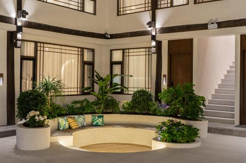 a lobby with a circular seating area with plants at Yijianju Garden Inn in Lijiang