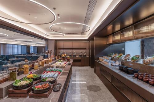 Una línea de buffet en un restaurante con comida. en Orange Crystal Nanchang Honggutan MixC Hotel, en Nanchang