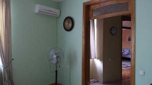 a room with a fan and a clock on the wall at Guest House kartvelishvili in Batumi