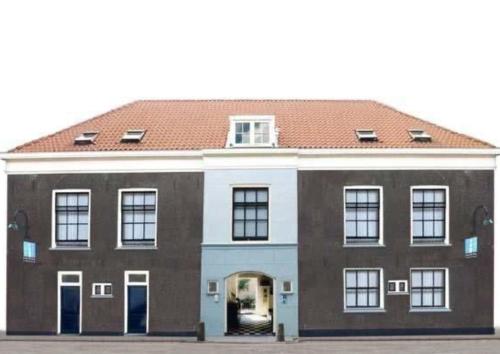 a large brick building with a red roof at The Guesthouse in Gouda