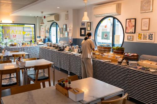 ラノーンにあるThe Galla Hotelの店の窓口に立つ者