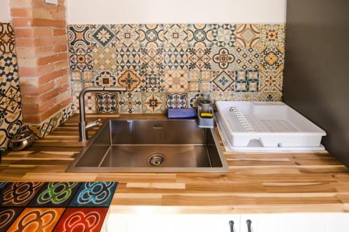 a kitchen with a sink and a tile wall at Rural apartment La Cantonada in Guardiola de Berguedà