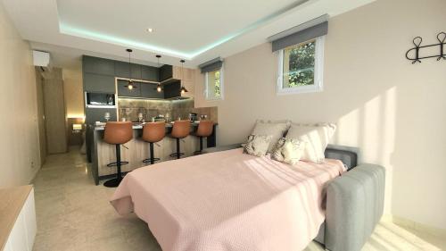 ein Schlafzimmer mit einem rosa Bett und einer Küche in der Unterkunft Appartement de standing avec jacuzzi in Le Val