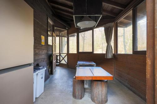 a kitchen with a table in a room with windows at 秋保木の家ロッジ村 in Sendai