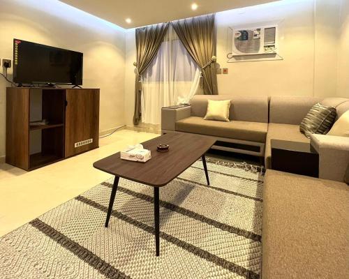 a living room with a couch and a table at Bright Star Hotel in AlUla