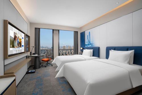 Una cama o camas en una habitación de Hampton by Hilton Kunming Railway Station