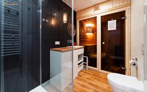 a bathroom with a glass shower and a toilet at Apartamenty Wonder Home z pięknymi widokami na góry, blisko terenów spacerowych i szlaków in Karpacz