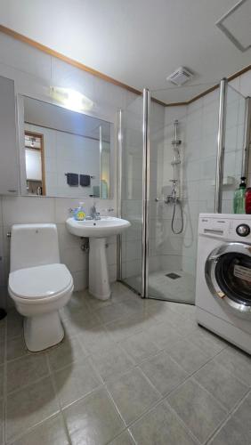 a bathroom with a toilet and a sink and a washing machine at Paradise Hongdae in Seoul