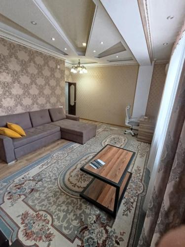 Центр في بيشكيك: غرفة معيشة بها أريكة وطاولة