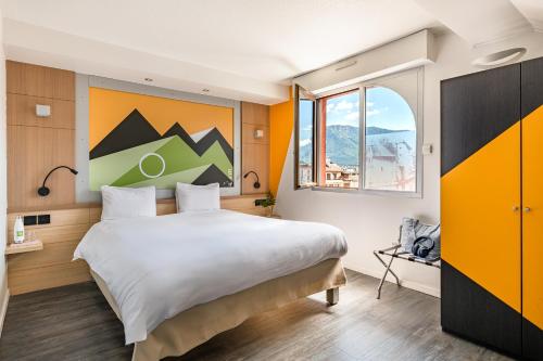 a hotel room with a large bed and a window at ibis Styles Annecy Centre Gare in Annecy