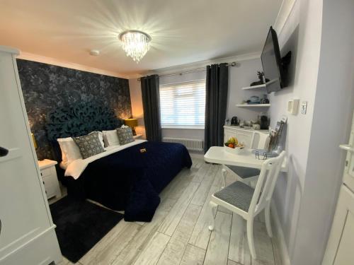 a bedroom with a bed and a desk and a desk at THE KNIGHTWOOD OAK a Luxury King Size Bed -En-Suite Space - LYMINGTON NEW FOREST with Private Entrance - Key Box entry-Free Parking & Private Outdoor Seating Area -Full Fibre WiFi -Town ,Shops , Pubs & Solent Way Walking Distance & Complimentary Breakfast in Lymington