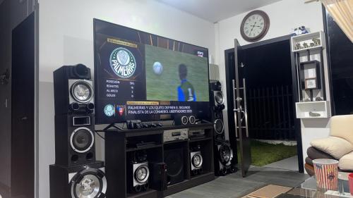 ein Wohnzimmer mit einem Fernseher und einigen Lautsprechern in der Unterkunft Habitación doble # 3 in Macas