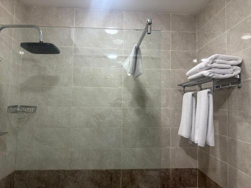 a shower with white towels in a bathroom at Salam Baku Hotel (SBH) in Baku