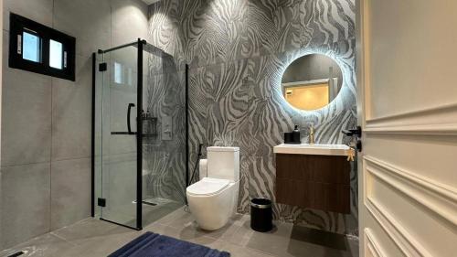 a bathroom with a shower and a toilet and a mirror at Mawimbi Zanzibar in Paje