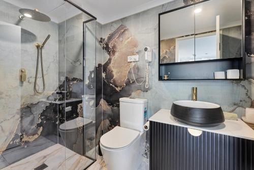 a bathroom with a shower and a toilet and a sink at Stylish 1-Bedroom Stay with Balcony & Amenities in Sydney