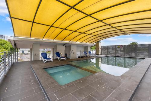 a swimming pool on the roof of a building at Stylish 1-Bedroom Stay with Balcony & Amenities in Sydney