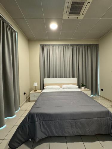 a bedroom with a large bed with gray curtains at Dimora Sovrana in Laurignano
