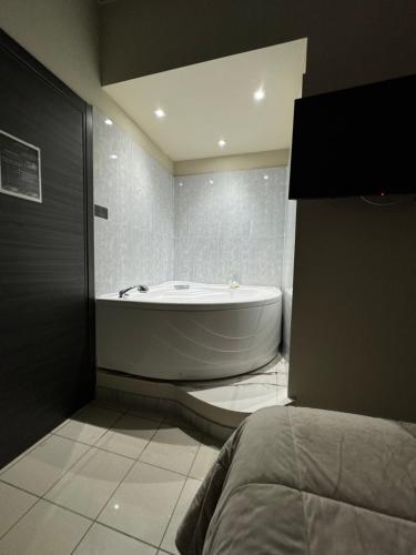 a bathroom with a bath tub and a bed at Dimora Sovrana in Laurignano