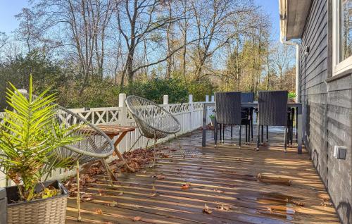 a wooden deck with chairs and a table on it at Beautiful Home In Oksbøl With Sauna in Øster Vrøgum