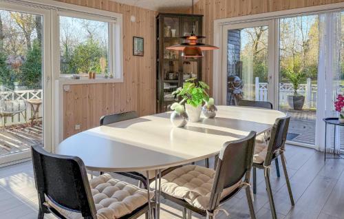 a dining room with a white table and chairs at Beautiful Home In Oksbøl With Sauna in Øster Vrøgum