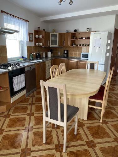 a kitchen with a wooden table and chairs in it at Rekreační dům Strachotín in Strachotín