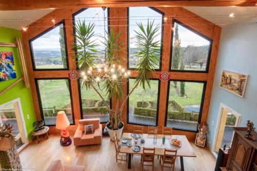 a living room with a table and a bunch of windows at Chambre Rambouillet, Au Domaine du Cerf in Vyans