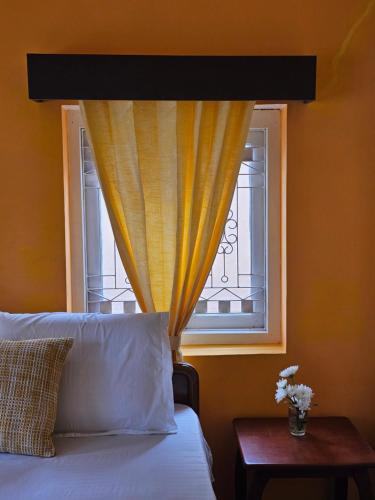 ein Schlafzimmer mit einem Bett und einem Fenster in der Unterkunft The Cottage Coonoor AS in Coonoor