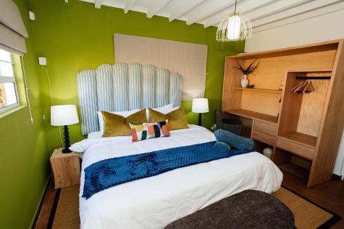 a bedroom with a large bed with green walls at Park Road Apartments in Howick