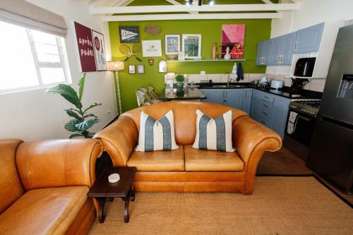 a living room with a leather couch in a kitchen at Park Road Apartments in Howick