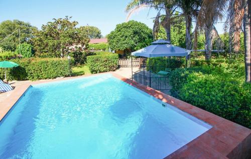 una grande piscina blu con ombrellone di Stunning Home In Siracusa a Floridia