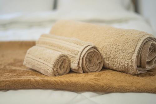 イオアニナにあるnuvéのベッドの上に置かれたタオルの山