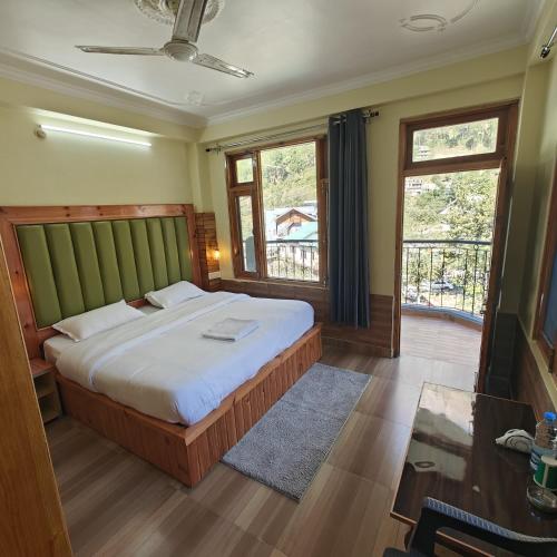 a bedroom with a large bed and a window at Qpoint hotel in Kasol