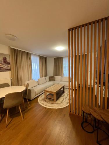 een woonkamer met een bank en een tafel bij Sarajevo Waves Aparthotel in Sarajevo