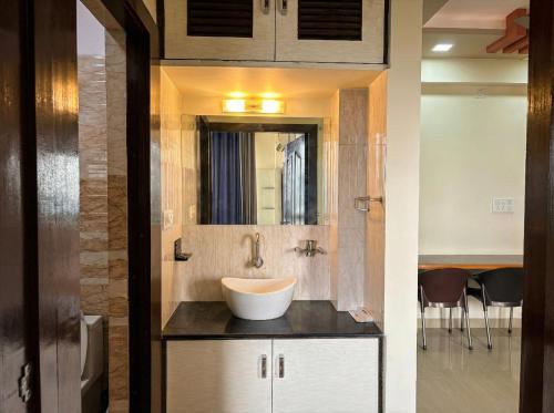 un baño con lavabo y espejo en Avasa Homestay, en Thūr